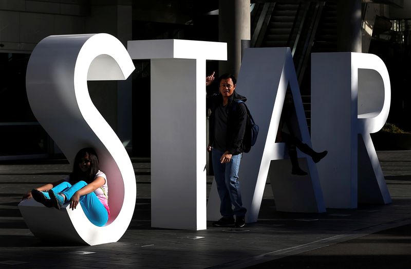 &copy; Reuters. A tourist poses for pictures at the main sign of The Star Casino at Pyrmont Bay in Sydney, Australia, July 4, 2013.   REUTERS/Daniel Munoz/File photo