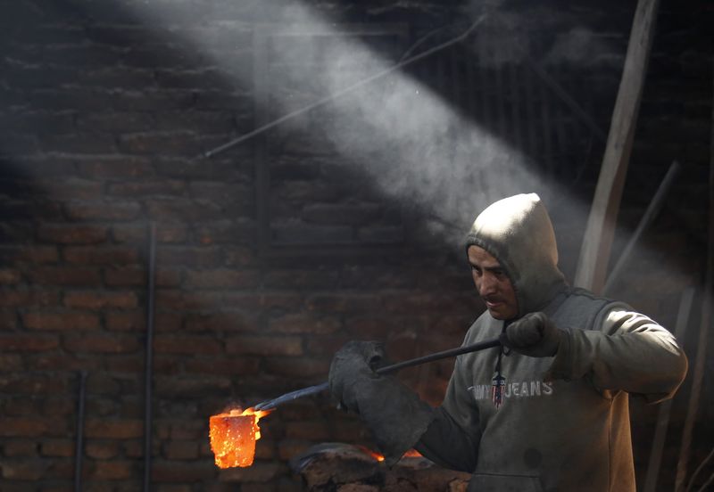 &copy; Reuters. A worker carries a crucible of melted copper as he makes statues at a workshop in Lalitpur, Nepal December 23, 2015. REUTERS/Navesh Chitrakar/File Photo