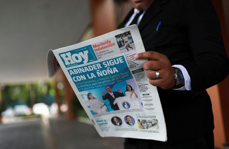 © Reuters. A man reads a newspaper outside of a buillding, a day after the general election in Santo Domingo, Dominican Republic, May 20, 2024. REUTERS/Henry Romero