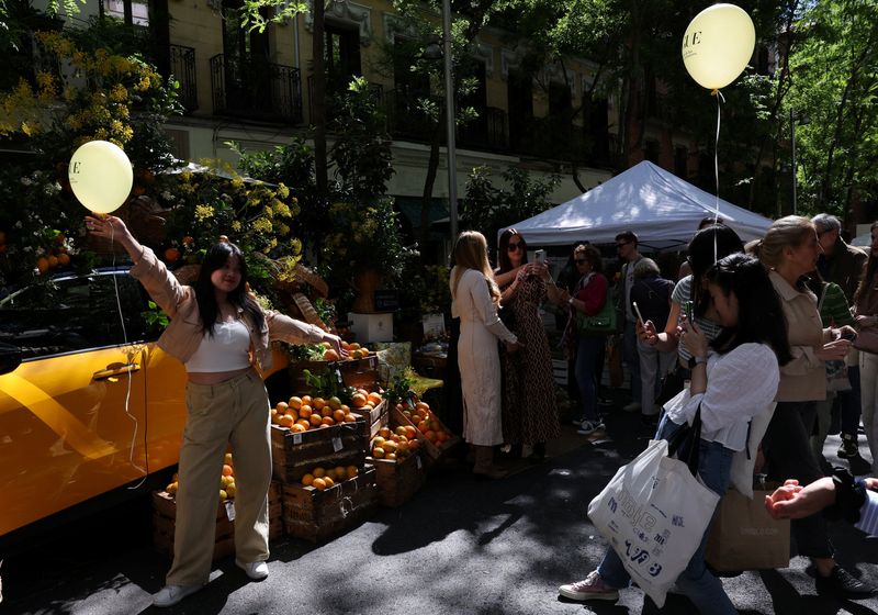 &copy; Reuters. Tourists from China take photos at an outdoor market in the downtown district of Salamanca, in Madrid, Spain, May 18, 2024. REUTERS/Violeta Santos Moura/File Photo