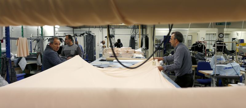 &copy; Reuters. FILE PHOTO: Men work on cutting material at the Fashion Enter factory in London England, January 8, 2016. REUTERS/Eddie Keogh/File photo