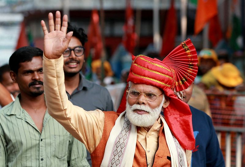 © Reuters. FILE PHOTO: A supporter and lookalike of Indian Prime Minister Narendra Modi waves before the start of a roadshow by Prime Minister Modi in Kochi, India, January 16, 2024. REUTERS/Sivaram V/File Photo