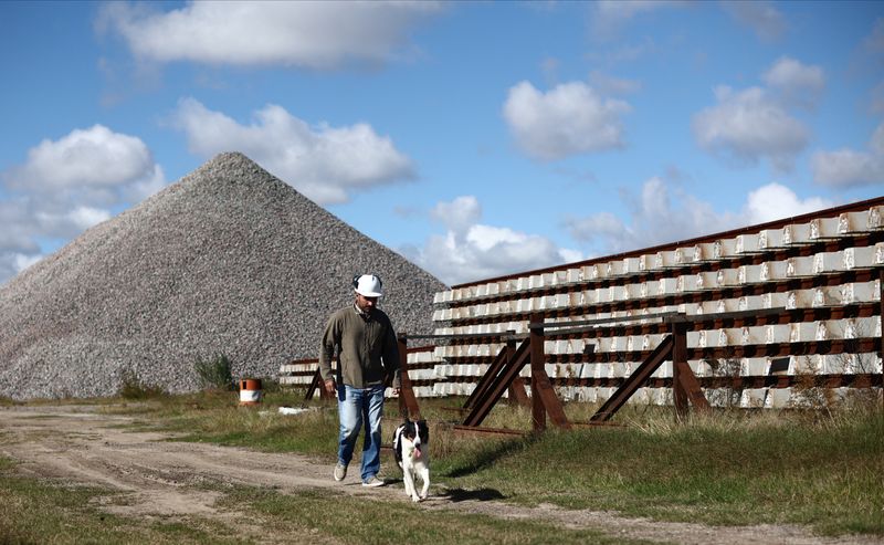 &copy; Reuters. Engineer Agustin Pecora, 33, walks with his dog at a stalled railway construction site where he is in charge of protecting the idled machinery and building materials from theft, in La Plata, Argentina May 14, 2024. REUTERS/Tomas Cuesta