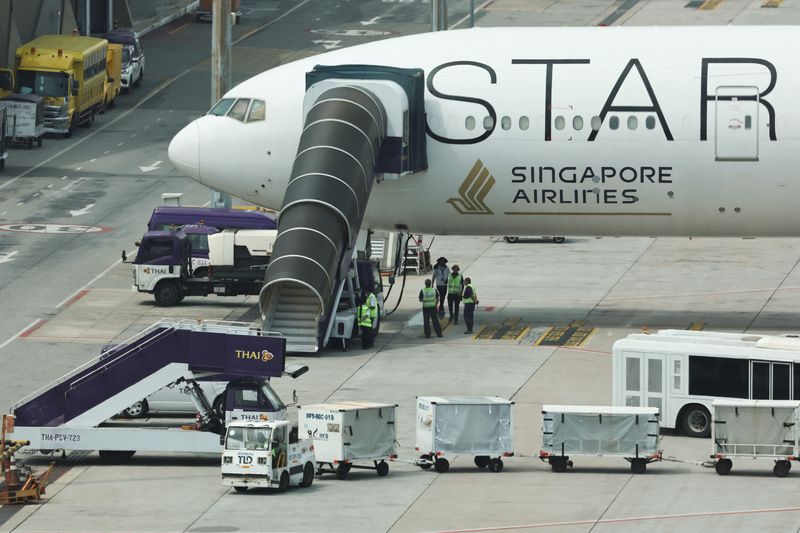 &copy; Reuters. Airport officials stand near the Singapore Airlines aircraft for flight SQ321 parked on the tarmac after an emergency landing at Suvarnabhumi International Airport, in Bangkok, Thailand, May 22, 2024. REUTERS/Athit Perawongmetha