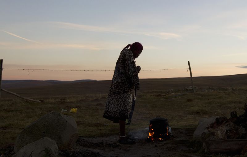 &copy; Reuters. FILE PHOTO: A woman warms water on an open fire near the home of former South African President Nelson Mandela's house in Qunu, June 28, 2013. REUTERS/Rogan Ward/File Photo