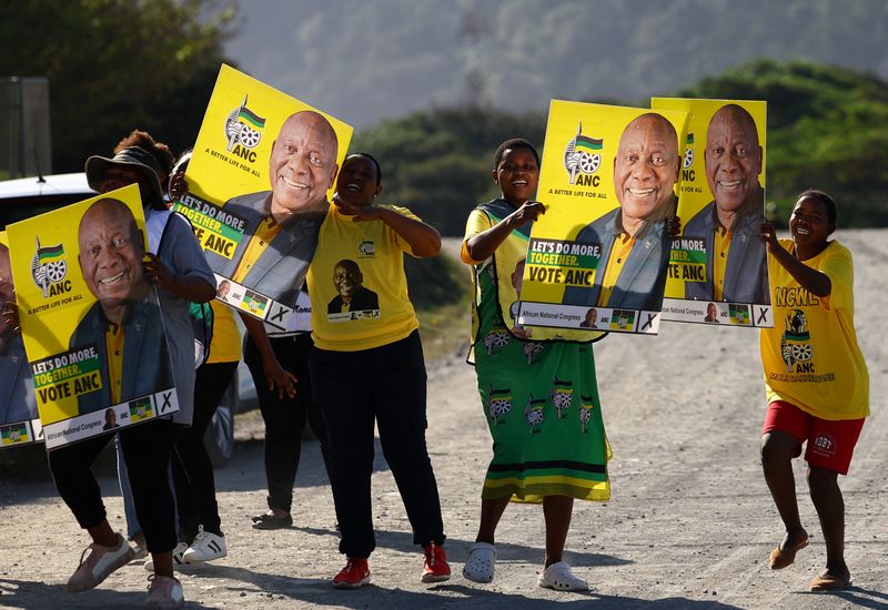 © Reuters. Supporters of the ANC hold placards bearing the face of South Africa's and ANC President Cyril Ramaphosa at Port St. Johns, in the eastern Cape province of South Africa May 5, 2024. REUTERS/Siphiwe Sibeko