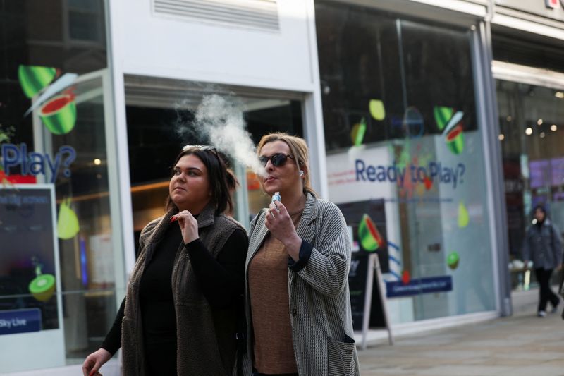 &copy; Reuters. FILE PHOTO: A woman holds an e-cigarette as she vapes on a street in Manchester, Britain March 6, 2024. REUTERS/Temilade Adelaja