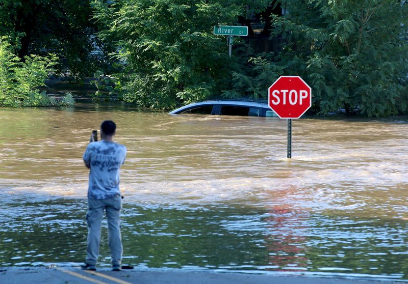 © Reuters. A man takes photos of a submerged car as the remnants of Hurricane Ida brought torrential rains and flooding to the area in Passaic, New Jersey, U.S., September 2, 2021.  Thomas P. Costello/USA TODAY Network via REUTERS/File Photo