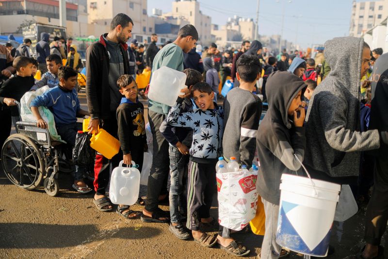 © Reuters. FILE PHOTO: Palestinians queue as they wait to collect drinking water, amid shortages of drinking water, as the conflict between Israel and Hamas continues, in Rafah, in the southern Gaza Strip January 4, 2024.  REUTERS/Saleh Salem/File Photo