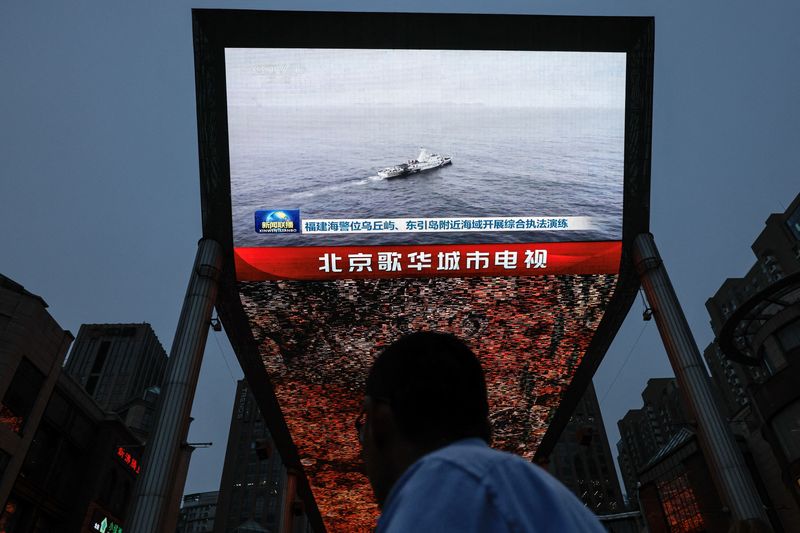 &copy; Reuters. A person looks at a screen showing news footage of military drills conducted in areas around the island of Taiwan by the Eastern Theatre Command of the Chinese People's Liberation Army (PLA), in Beijing, China May 23, 2024. REUTERS/Tingshu Wang