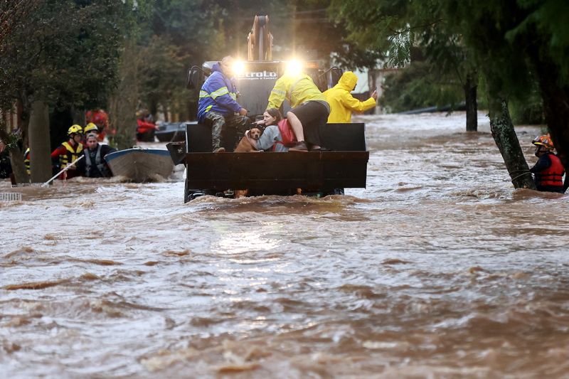 &copy; Reuters. Rescue workers evacuate a woman and her pet from a flooded area at Cavalhada neighborhood, after heavy rains in Porto Alegre, May 23, 2024. REUERS/Diego vara