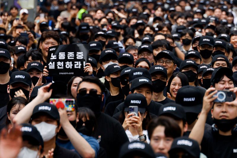 &copy; Reuters. A member of the National Samsung Electronics Union (NSEU) holds a placard that reads "Respect labour" in front of the Samsung Electronics Seocho Building in Seoul, South Korea, May 24, 2024. REUTERS/Kim Soo-hyeon
