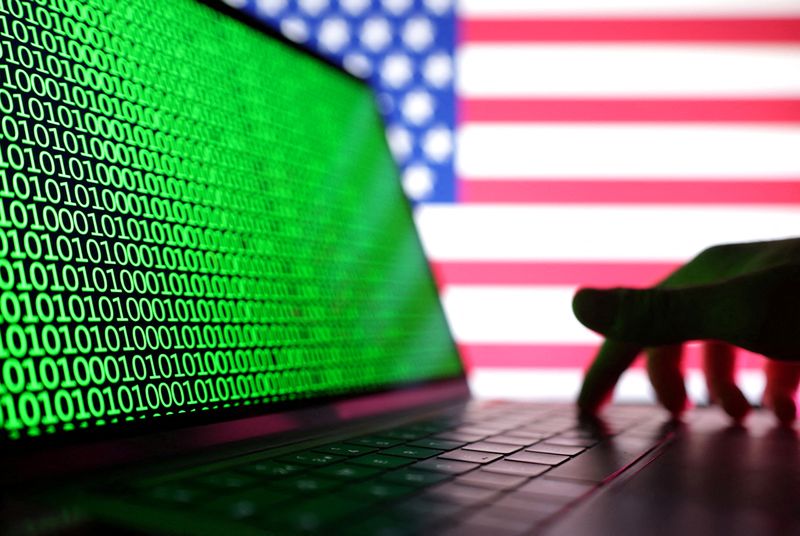 &copy; Reuters. FILE PHOTO: A hand is seen on a laptop with binary codes displayed in front of the USA flag in this illustration taken, August 19, 2022. REUTERS/Dado Ruvic/Illustration/File Photo