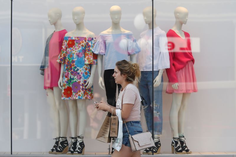 &copy; Reuters. A woman carries shopping bags while walking past a window display outside a retail store in Ottawa, Ontario, Canada, July 21, 2017. REUTERS/Chris Wattie/File Photo