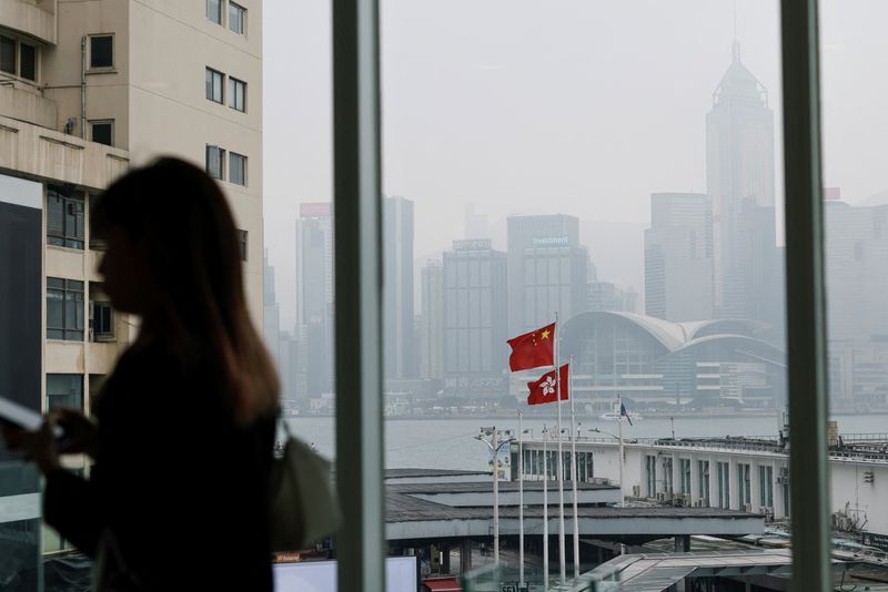 © Reuters. FILE PHOTO: Chinese and Hong Kong flags are seen at the waterfront during a foggy day in Hong Kong, China, March 6, 2024. REUTERS/Tyrone Siu/File photo