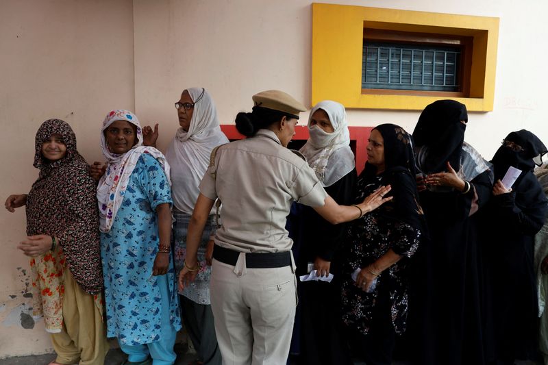 &copy; Reuters. A police officer asks women to maintain a line as they wait to cast their votes at a polling station during the sixth phase of India’s general election in New Delhi, India, May 25, 2024. REUTERS/Priyanshu Singh