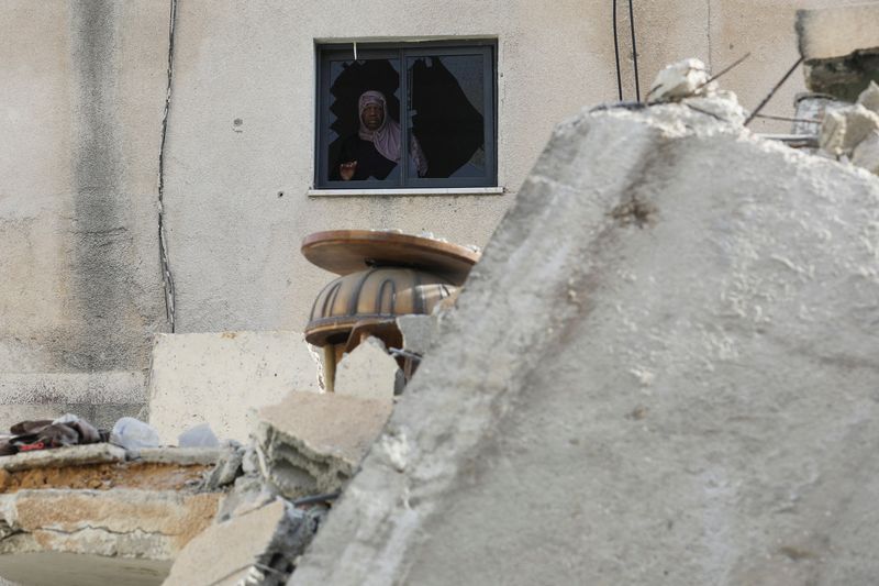 &copy; Reuters. FILE PHOTO: A Palestinian woman looks out of a broken window, in the aftermath of an Israeli raid on Jenin camp in the Israeli-occupied West Bank, May 23, 2024. REUTERS /Raneen Sawafta/File Photo