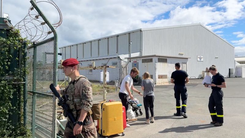 © Reuters. A soldier stands guard as evacuees arrive at the airport in Noumea, New Caledonia, May 25, 2024, in this screengrab obtained from a social media video.  Video obtained by Reuters/via REUTERS