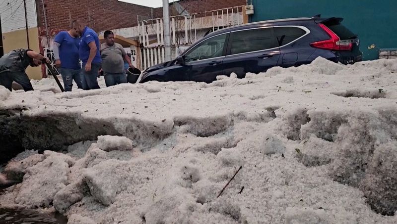 &copy; Reuters. People remove thick ice from a street following a hailstorm amid heat wave, in Puebla, Mexico May 24, 2024. REUTERS TV/Genaro Zepeda?