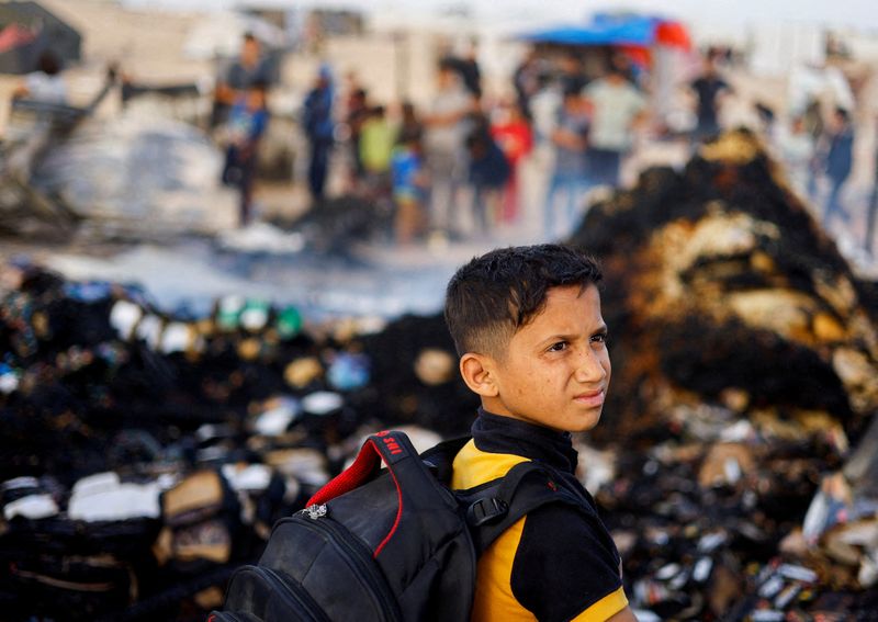 © رويترز.  صورة من الملف: صبي فلسطيني ينظر إلى موقع غارة إسرائيلية على منطقة مخصصة للنازحين، في رفح بجنوب قطاع غزة، 27 مايو، 2024. رويترز/محمد سالم/صورة أرشيفية