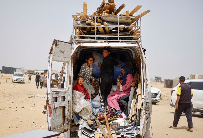 © Reuters. Displaced Palestinians of Salman family ride in a vehicle loaded with their belongings as they prepare to flee Rafah following a nearby Israeli strike on an area designated for displaced, in Rafah in the southern Gaza Strip, May 27, 2024. REUTERS/Mohammed Salem