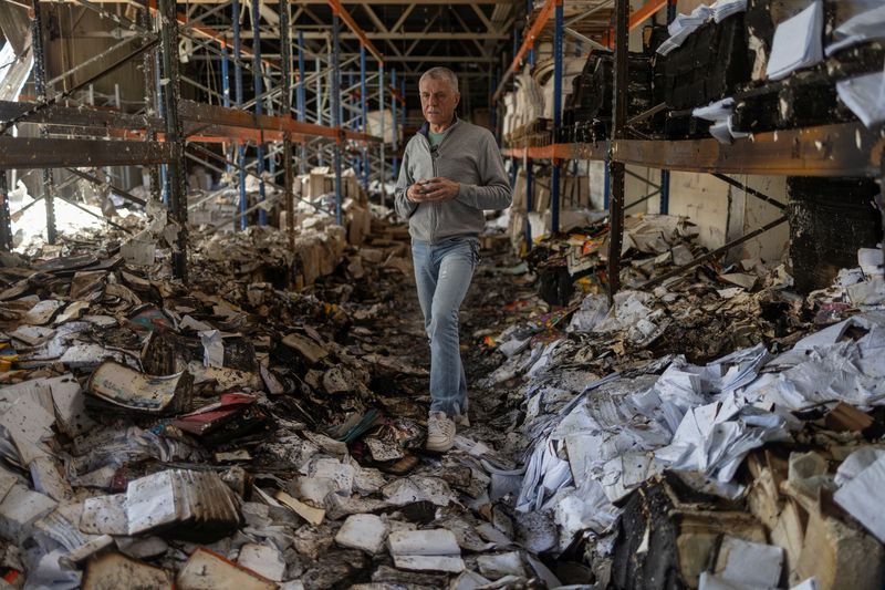 © Reuters. Sergii Polituchyi, Ukrainian publisher and businessman, stands between shelves with burned books in his printing house, which was badly damaged by a recent Russian missile strike, amid Russia's attack on Ukraine, in Kharkiv, Ukraine May 26, 2024. REUTERS/Valentyn Ogirenko