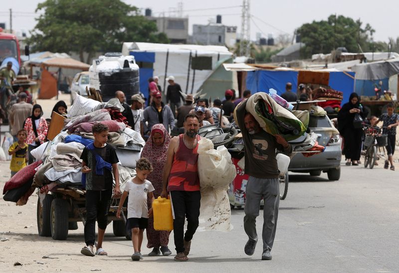 © رويترز.  فلسطينيون يسافرون سيرا على الأقدام مع ممتلكاتهم أثناء فرارهم من رفح بسبب عملية عسكرية إسرائيلية، في رفح بجنوب قطاع غزة، 28 مايو، 2024. رويترز / حاتم خالد