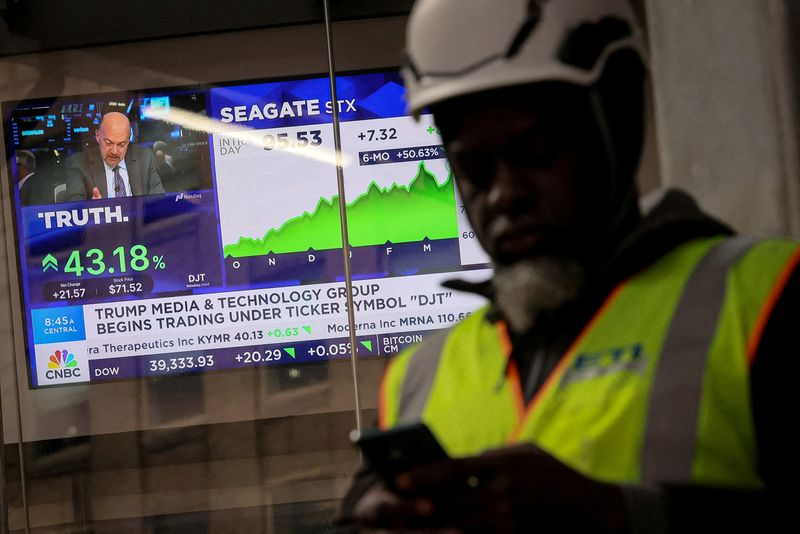 &copy; Reuters. FILE HOTO: A man looks at this phone as a screen displays trading information about shares of Truth Social and Trump Media & Technology Group, outside the Nasdaq Market site in New York City, U.S., March 26, 2024.  REUTERS/Brendan McDermid