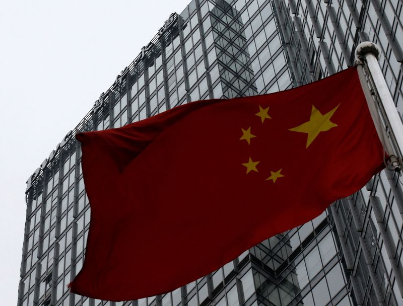 © Reuters. FILE PHOTO: A building housing the PricewaterhouseCoopers (PWC) branch office stands behind a Chinese national flag in Beijing January 24, 2014.      REUTERS/Kim Kyung-Hoon/File Photo