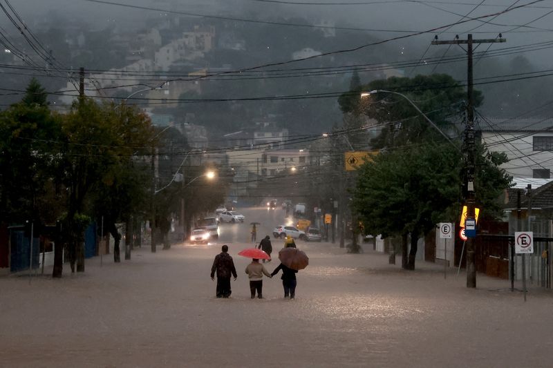 &copy; Reuters. Moradores de bairro de Cavalhada, em Poro Alegre, caminham pela enchente.nREUTERS/Diego Vara
