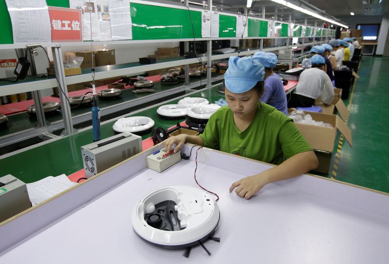 &copy; Reuters. FILE PHOTO: An employee works on the production line of a robot vacuum cleaner factory of Matsutek in Shenzhen, China August 9, 2019. REUTERS/Jason Lee/File Photo