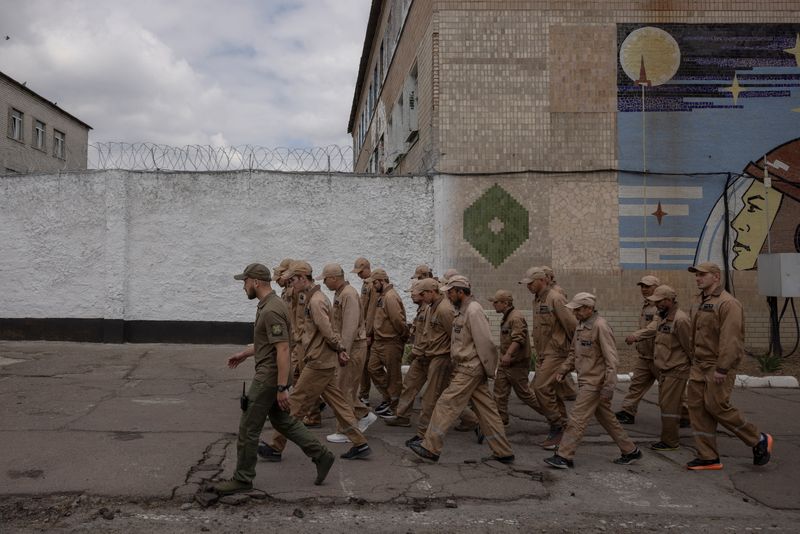 © Reuters. Inmates walk in a prison yard during a media event promoting a government offer to recruit some convicts for the military, in a prison colony in the Kyiv region, Ukraine, May 30, 2024.  REUTERS/Thomas Peter