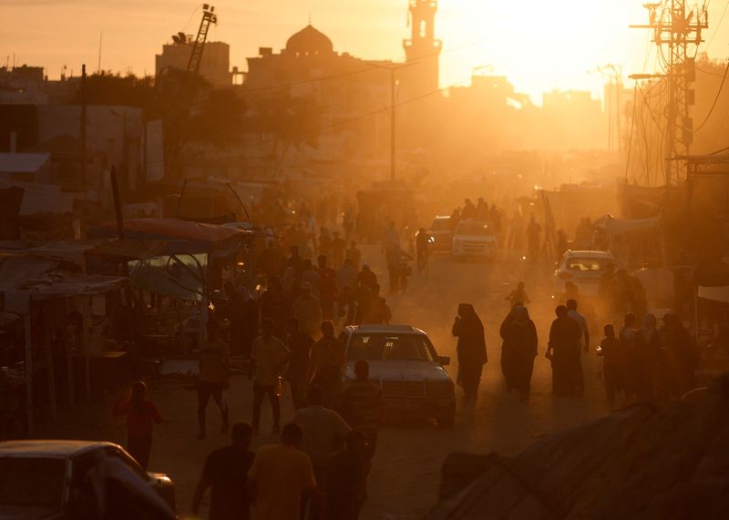 © Reuters. Palestinians walk amid houses destroyed in Israeli strikes, in Khan Younis, in the southern Gaza Strip, May 30, 2024. REUTERS/Mohammed Salem/ File Photo