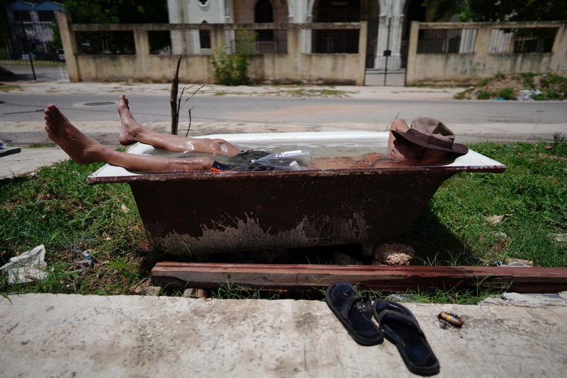 © Reuters. Retired painter Julio Rodriguez, 61, relaxes in a bathtub in front of his home in Havana, Cuba, July 19, 2023. REUTERS/Alexandre Meneghini/ File Photo