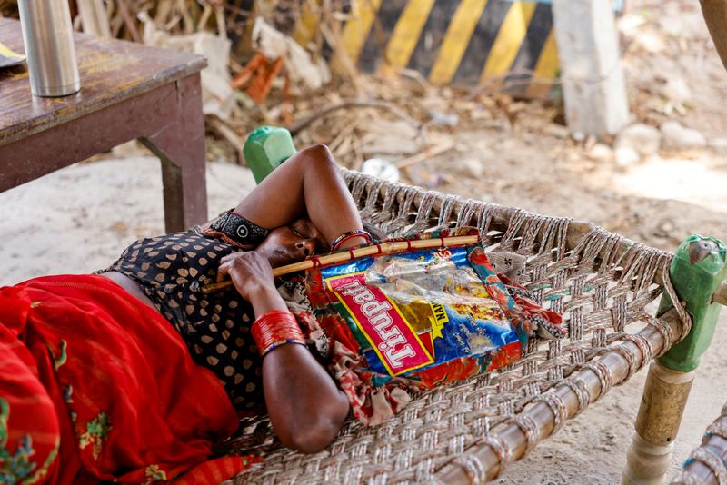 &copy; Reuters. A trabalhadora agrícola Khilona, ​​de 50 anos, dorme em cama com leque feito à mão sob um galpão em sua casa, nas planícies aluviais de Yamuna, em um dia quente de verão durante onda de calor n30/05/2024nREUTERS/Anushree Fadnavis