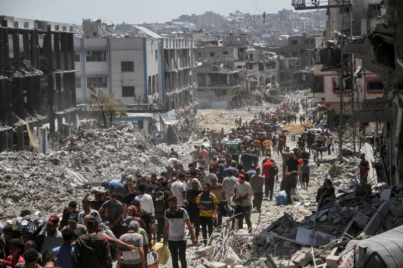 &copy; Reuters. Palestinians make their way as they inspect the damages after Israeli forces withdrew from a part of Jabalia refugee camp, following a raid, in the northern Gaza Strip, May 30, 2024. REUTERS/Mahmoud Issa     