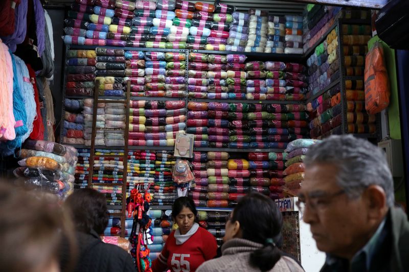 &copy; Reuters. FILE PHOTO: A woman sells cloth trimmings at a stand at Surco market in Lima, Peru August 31, 2018.  REUTERS/Mariana Bazo/File Photo