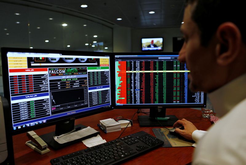 © Reuters. FILE PHOTO: A Saudi trader observes the stock market on monitors at Falcom stock exchange agency in Riyadh, Saudi Arabia February 7, 2018. REUTERS/Faisal Al Nasser/File Photo