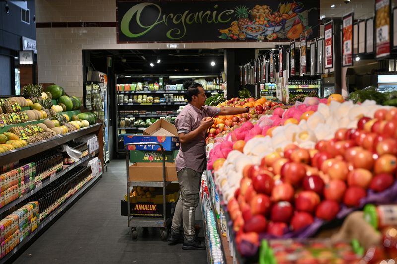 &copy; Reuters. FILE PHOTO: An employee stocks fruit at a specialty grocery store in Sydney, Australia, June 17, 2020.  REUTERS/Loren Elliott/File Photo