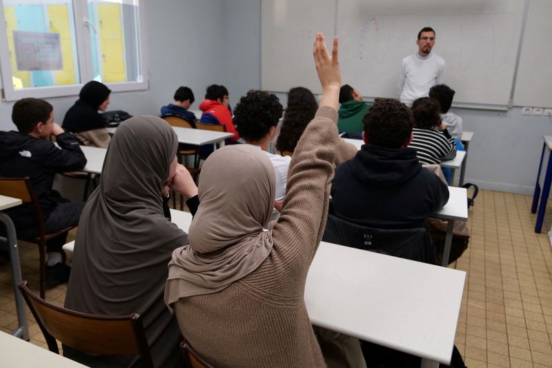 &copy; Reuters. A middle school student wearing a hijab raises her hand during an Islamic ethics class at the Averroes school, France's biggest Muslim educational institution that has lost its state funding on grounds of administrative failures and questionable teaching 