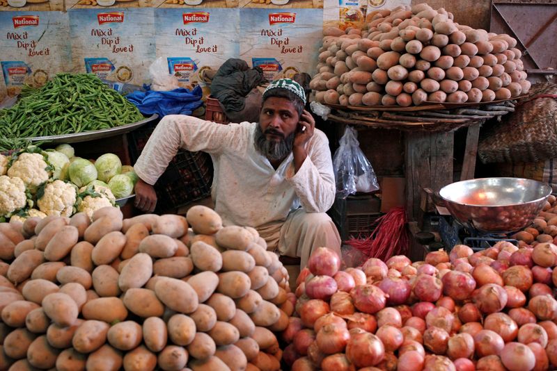 © Reuters. FILE PHOTO: A man selling vegetables waits for customers at his makeshift stall at the Empress Market in Karachi, Pakistan April 2, 2018. REUTERS/Akhtar Soomro/File photo