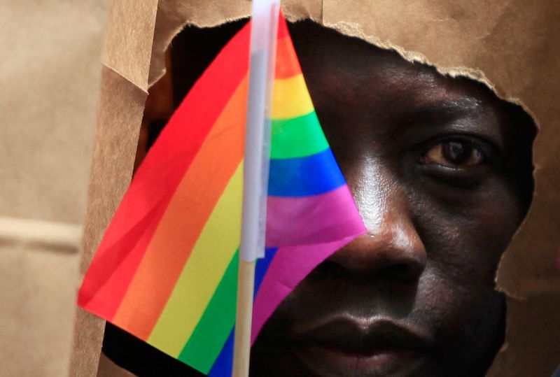 © Reuters. FILE PHOTO: An asylum seeker from Uganda covers his face with a paper bag in order to protect his identity as he marches with the LGBT Asylum Support Task Force during the Gay Pride Parade in Boston, Massachusetts June 8, 2013. REUTERS/Jessica Rinaldi/File Photo