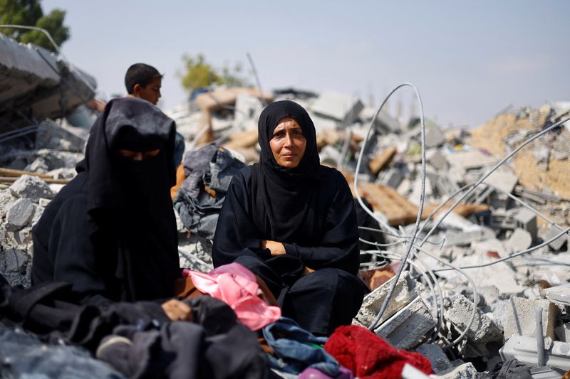 © Reuters. Palestinian sisters Samar and Sahar grieve as they search for their missing mother Amira Al-Breim at the rubble of a house hit in an Israeli strike, in Khan Younis in the southern Gaza Strip, June 3, 2024. REUTERS/Mohammed Salem