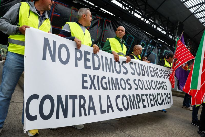 © Reuters. Farmers carry a sign reading 