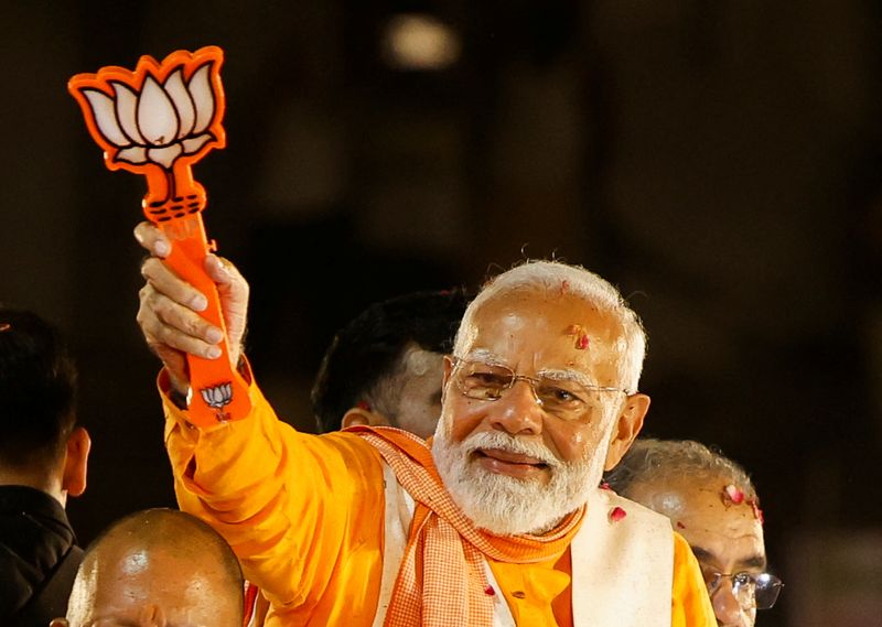 © Reuters.  Indian Prime Minister Narendra Modi shows the Bharatiya Janata Party (BJP) symbol during a roadshow as part of his election campaign, in Varanasi, India, May 13, 2024. REUTERS/Adnan Abidi/File Photo