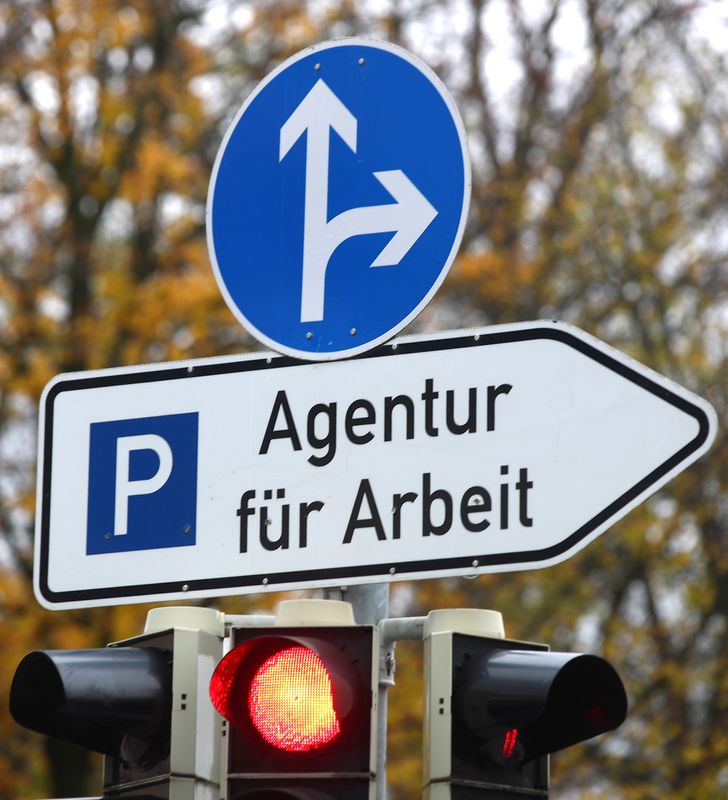 &copy; Reuters. FILE PHOTO: Traffic lights are seen below a sign leading to a job centre of Germany's Federal Labour Office in Munich, Germany November 8, 2017. REUTERS/Michael Dalder/File Photo