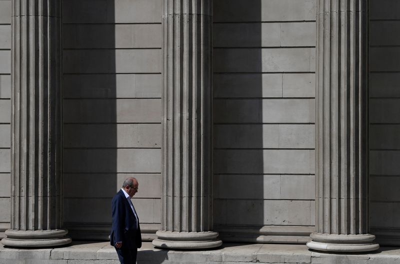 &copy; Reuters. FILE PHOTO: A worker walks past the Bank of England during the hot weather in the City of London financial district, London, Britain, July 19, 2022. REUTERS/Toby Melville/ file photo