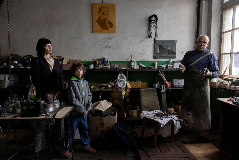 © Reuters. Dmytro Mamonov, his wife Oksana and daughter Yesenia stand in their workshop where they produce remote-controlled medical evacuation vehicles for the military, amid Russia's attack on Ukraine, at an undisclosed location in central Ukraine, May 31, 2024.  REUTERS/Thomas Peter