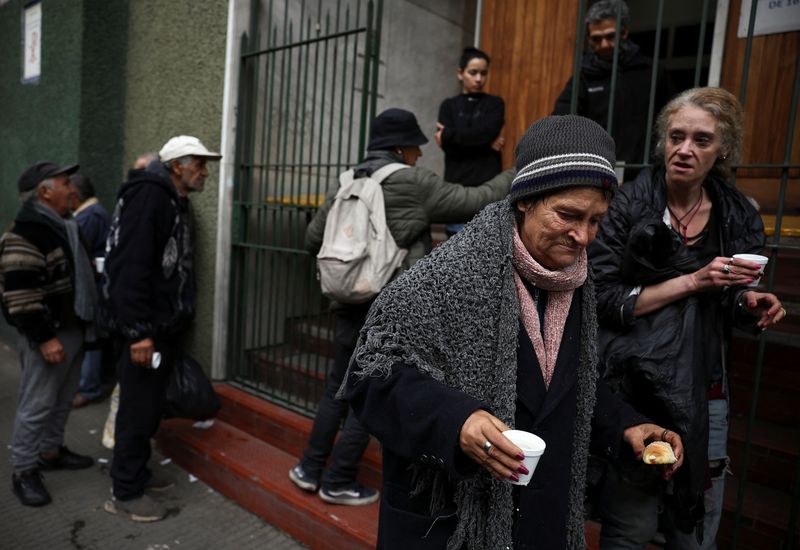 &copy; Reuters. Mulher se afasta de fila após receber alimento de igreja que auxilia os pobres em Buenos Airesn31/05/2024 REUTERS/Agustin Marcarian