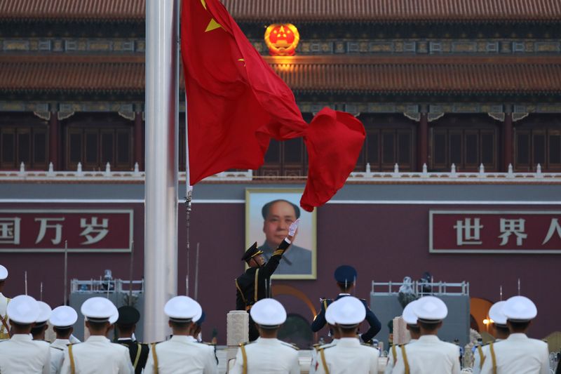 © Reuters. FILE PHOTO: Members of Chinese People's Liberation Army (PLA) attend a flag-raising ceremony at Tiananmen Square, in Beijing, China June 16, 2021. REUTERS/Tingshu Wang/File Photo